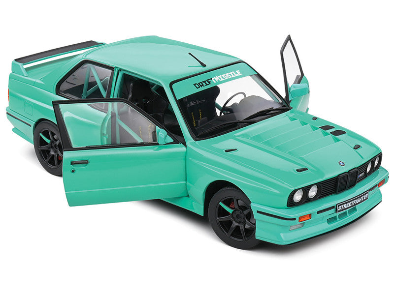 Turquoise model car with open door on a white background