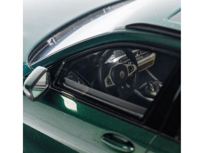Close-up of a car's interior with a steering wheel and dashboard, reflected in the windshield.