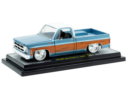 Model of a blue and brown pickup truck on a display stand with a white background