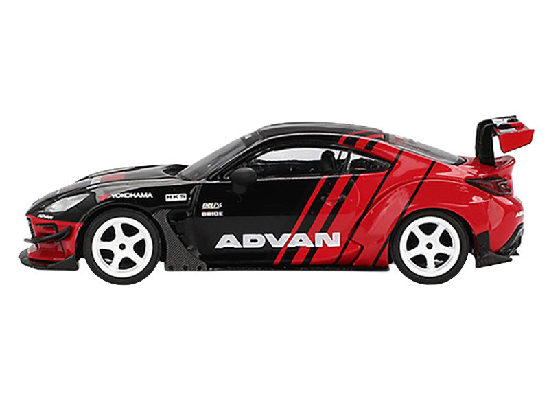 Red and black toy car with 'Advan' branding on a white background