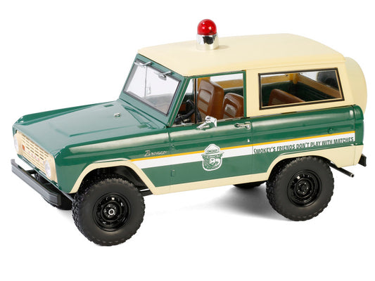 Model of a green and beige SUV with a red light on top, on a white background