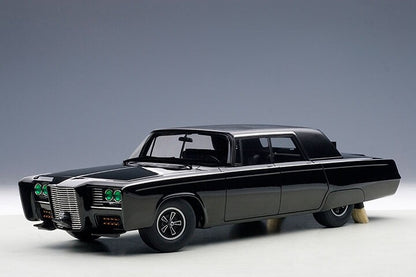 Black Diecast Model car with green headlights on a gray background