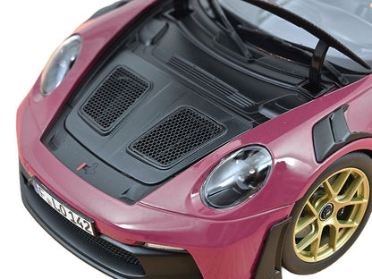 Close-up of a pink sports car with gold rims on a white background