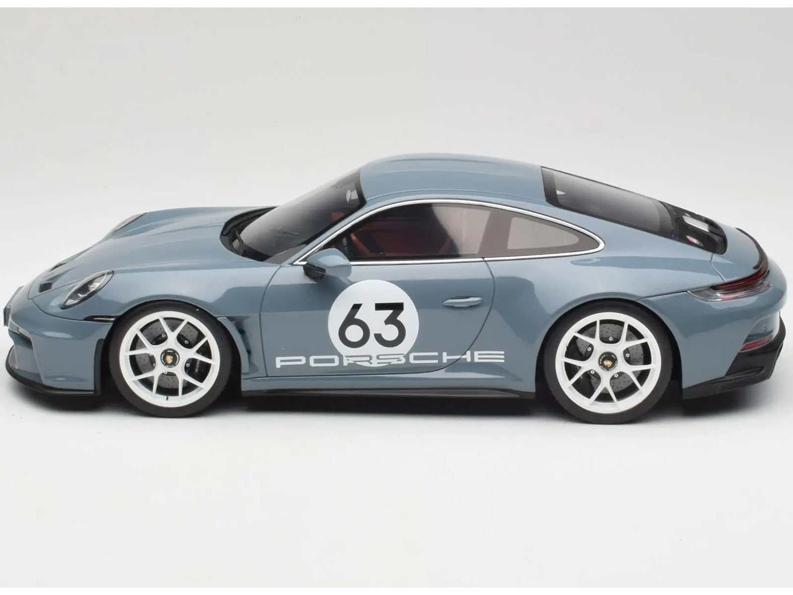 Model car of a Porsche with the number 63 on a white background