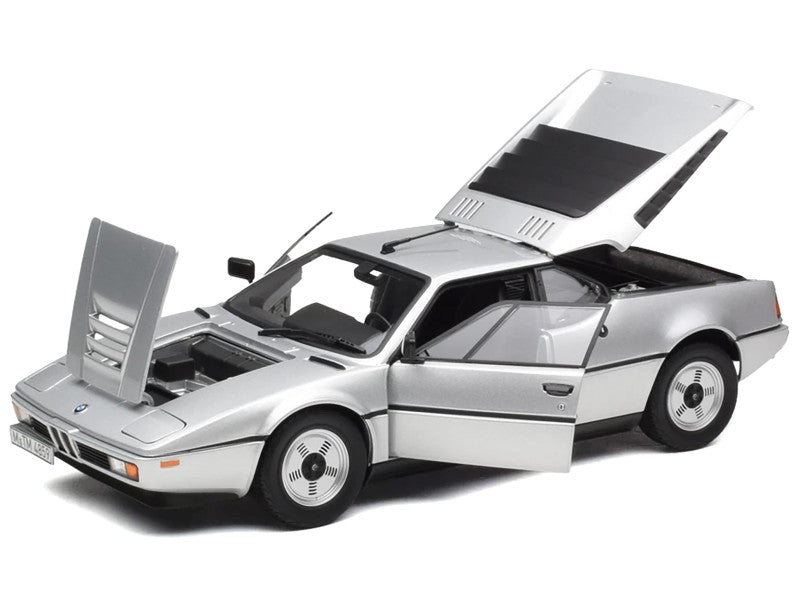 Model of a silver sports car with open doors on a white background