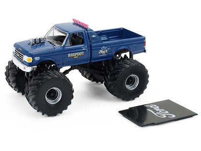 Blue monster truck model with large wheels on a white background