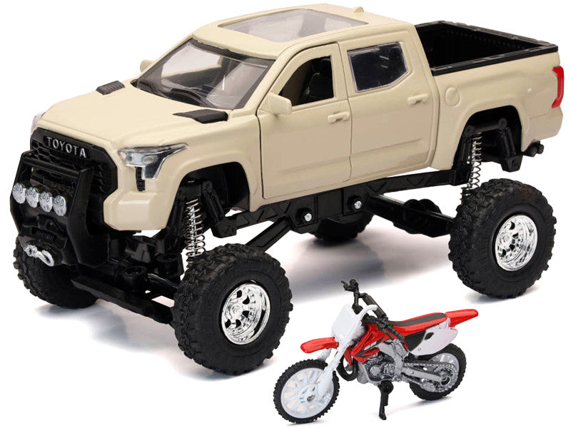 Toy Toyota truck with large wheels and a toy dirt bike on a white background