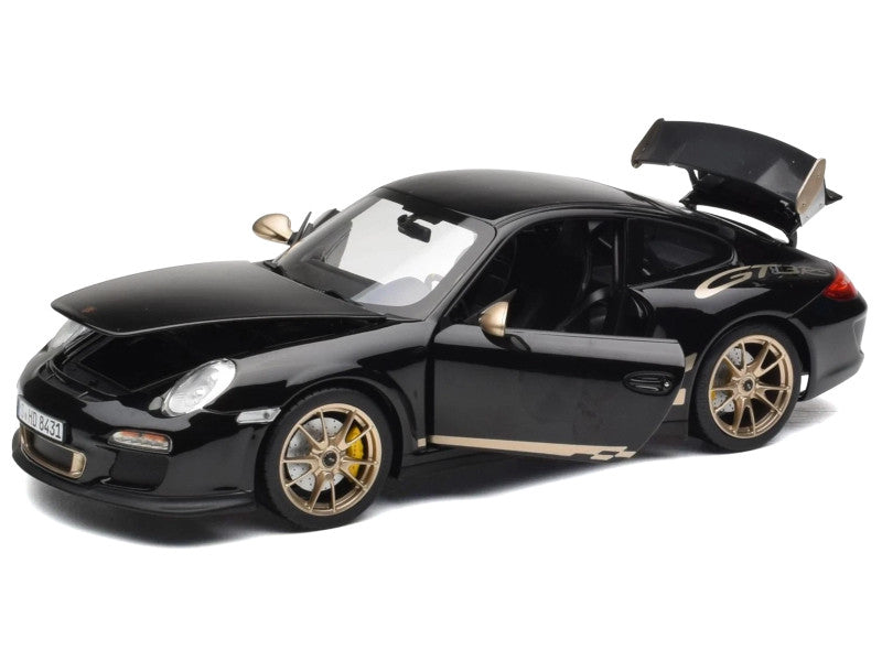 Black sports car model with open door on a white background