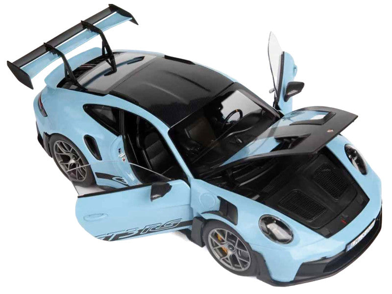 Light blue sports car model with open door on a white background