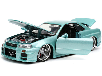 Light blue model car with open doors on a white background