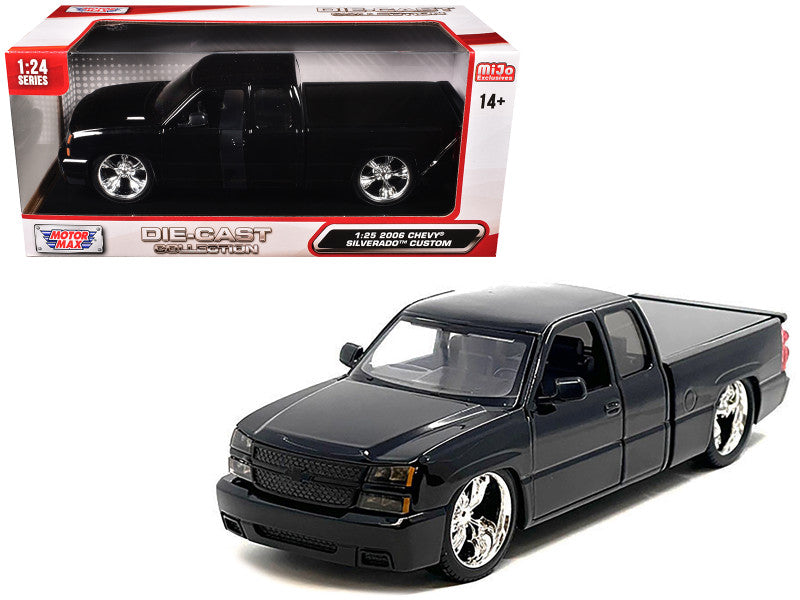 Black model truck in front of its packaging