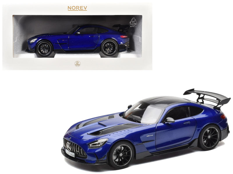 Blue sports car model with black roof and spoiler, displayed in front of its packaging.