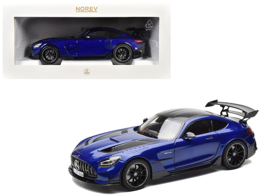 Blue sports car model with black roof and spoiler, displayed in front of its packaging.
