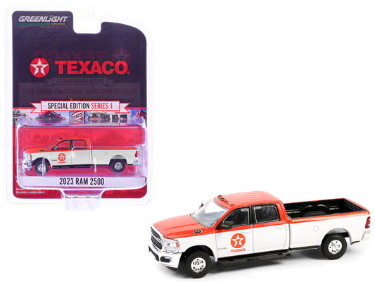 A 1/64 scale diecast model of a 2023 Ram 2500 Pickup Truck in orange and white 'Texaco' livery, with the Texaco logo and branding visible on the packaging.