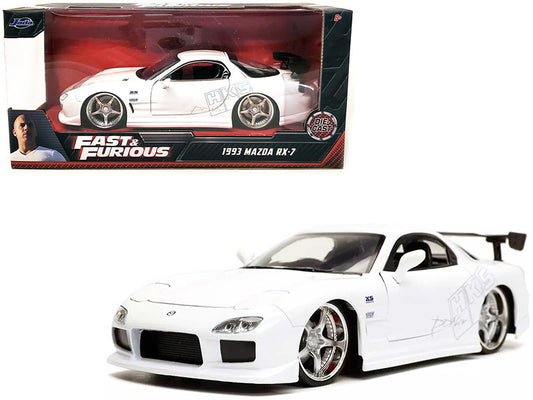 White model car of a Mazda RX-7 from 'Fast & Furious' series in front of its packaging.