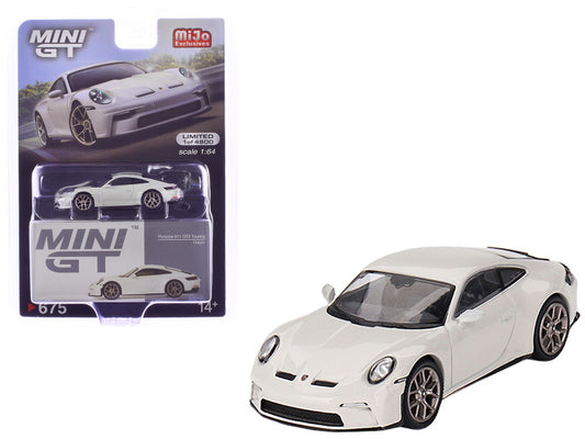 A white Porsche 911 (992) GT3 Touring diecast model car with detailed design, displayed both in and out of its packaging.