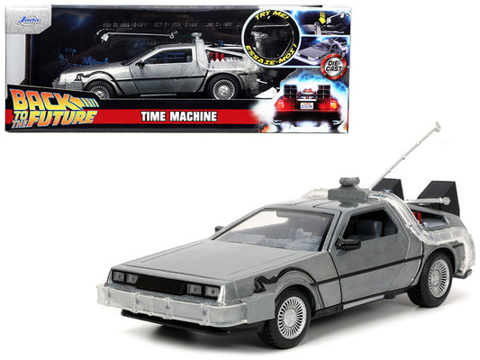 A diecast model of the DeLorean Time Machine from the movie 'Back To The Future'. The model is in silver color with detailed exterior and is approximately 1/24 scale.