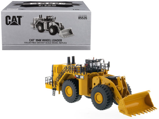 Caterpillar 994K Wheel Loader diecast model in yellow and black colors, showing the front view with the brand name visible on the box.