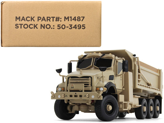 A 1/50 scale diecast model of a Mack Defense M917A3 Heavy Dump Truck in tan color, with a box in the background indicating the product's packaging.