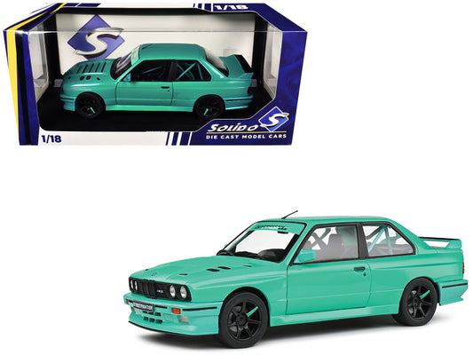 Green model car in front of its packaging with Siku branding