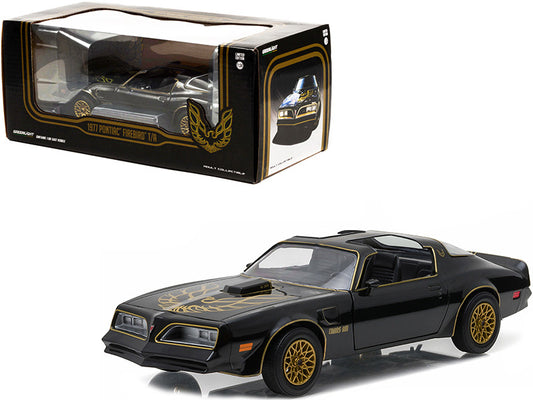 Black and gold model car with flame design in front of its packaging