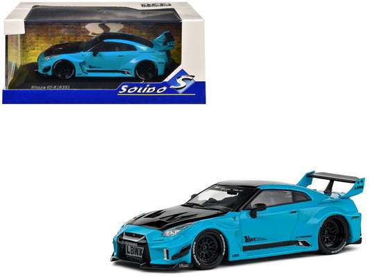 Blue sports car model with black roof and spoiler, displayed in front of its packaging.