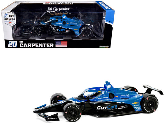 A diecast model of the Dallara IndyCar #20 Ed Carpenter in blue and black livery, with the car visible in its original packaging.