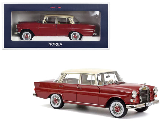 A 1:18 scale die cast model of a 1966 Mercedes-Benz 200 in red with beige top, manufactured by Norev, displayed in its packaging.