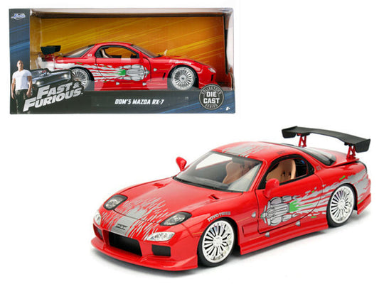 Red toy car with black spoiler from 'Fast & Furious' series in front of its packaging.
