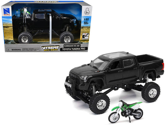 Black toy truck with large wheels and a smaller green toy bike on a white background, with a toy truck box in the background.