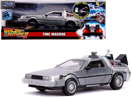 A 1/24 scale die cast model of the DeLorean Brushed Metal Time Machine from the movie 'Back to the Future 2' with lights, in a silver color, displayed in its packaging.