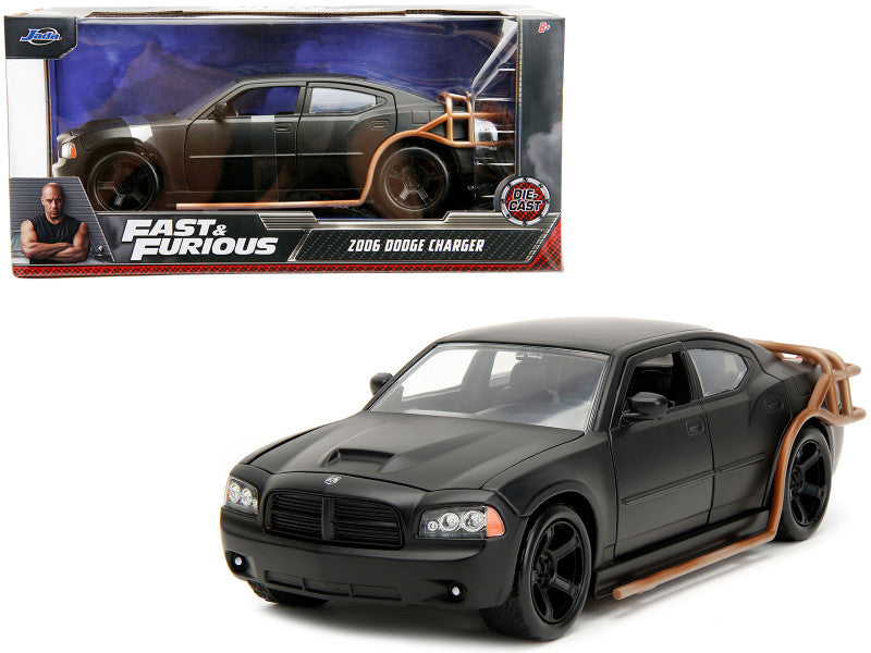 Black Dodge Charger model car from 'Fast & Furious' series in front of its packaging