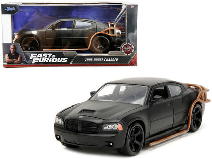 Black Dodge Charger model car from 'Fast & Furious' series in front of its packaging