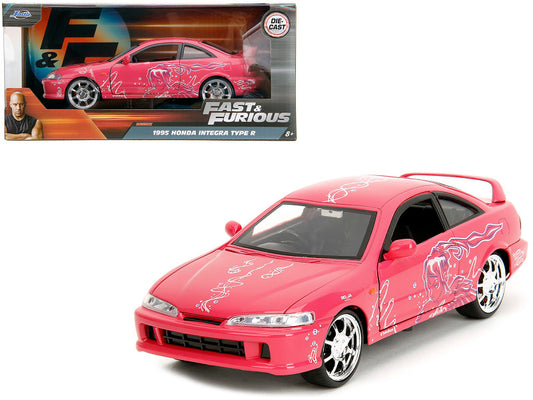 A 1/24 scale diecast model of a pink 1995 Honda Integra Type R from the 'Fast & Furious' movie series.