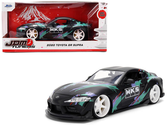 Model car of a 2020 Toyota GR Supra with HKS branding, displayed in front of its packaging.